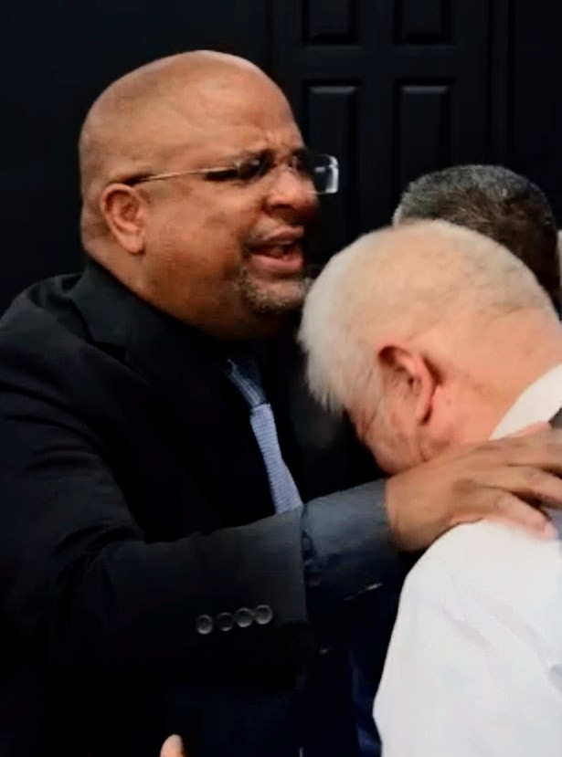 Two brothers in Christ embracing during service